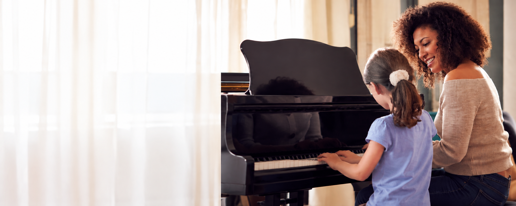 Bambina e insegnante durante una lezione di pianoforte